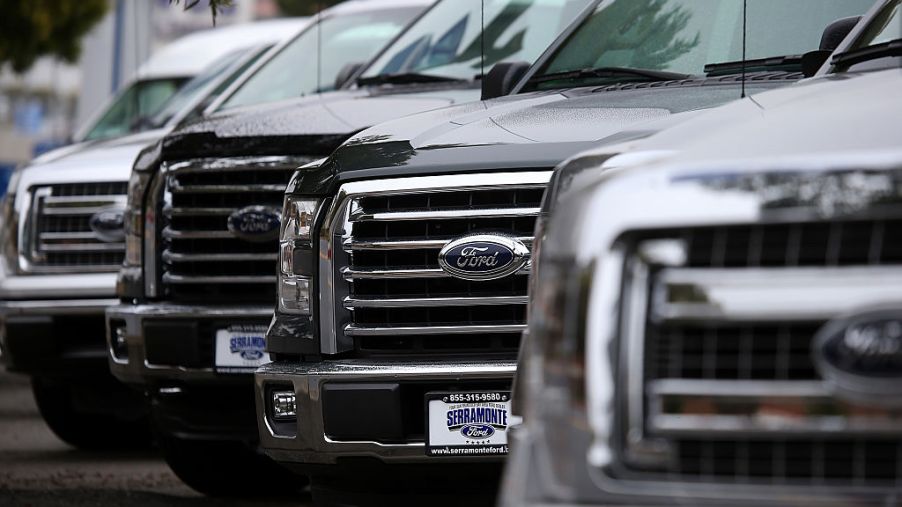 A line of new Ford F Series trucks at a dealership.