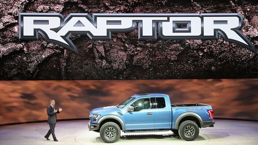 A spokesman showing a Ford Raptor on stage at an event.
