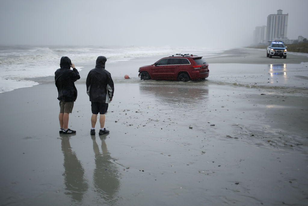 A red Jeep stranded on a beach during Hurricane Dorian