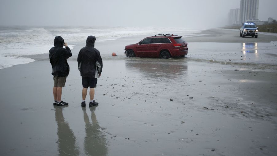 A red Jeep stranded on a beach during Hurricane Dorian