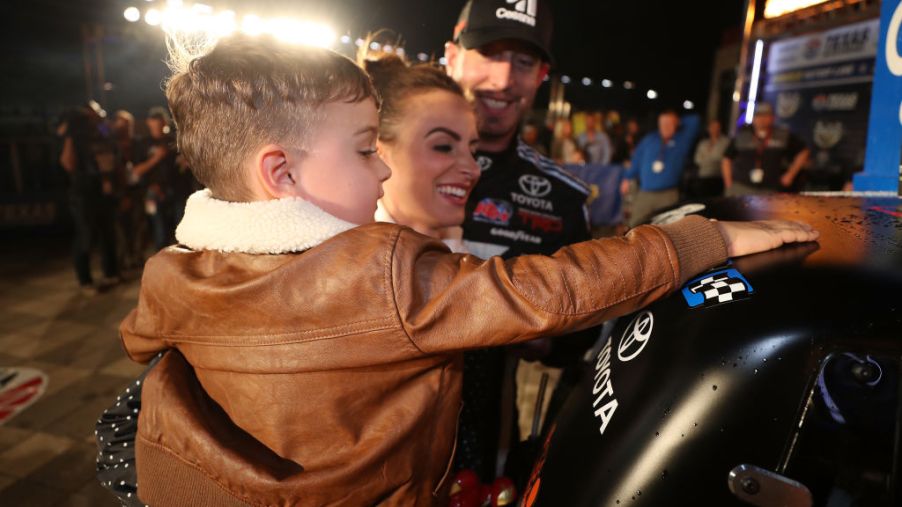 Kyle Busch, driver of the #51 Cessna Toyota, celebrates with his son Brexton and his wife Samantha by placing the Winner's sticker on his ca