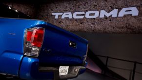 A 2016 Toyota Tacoma with it's tailgate on display at an auto show.
