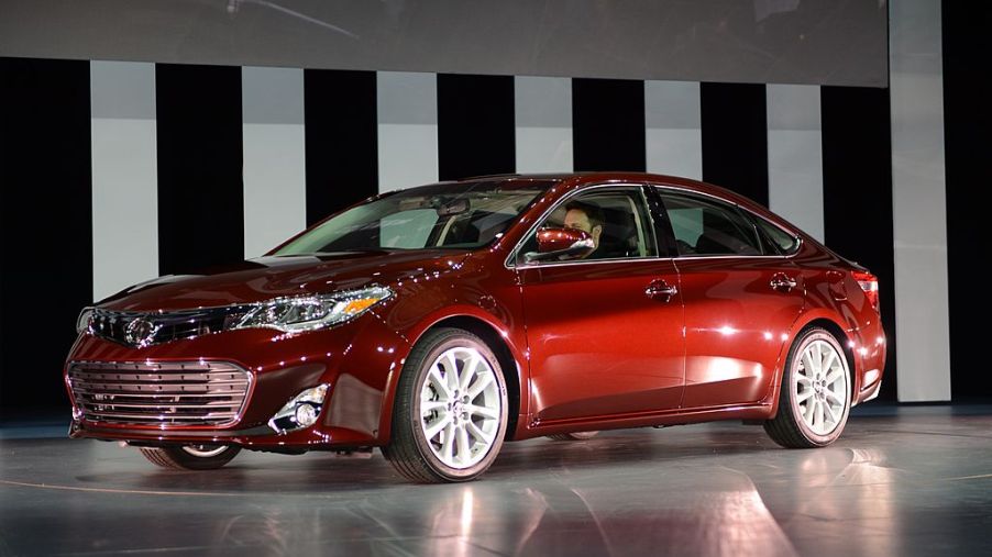 A red Toyota Avalon on display at an auto show.