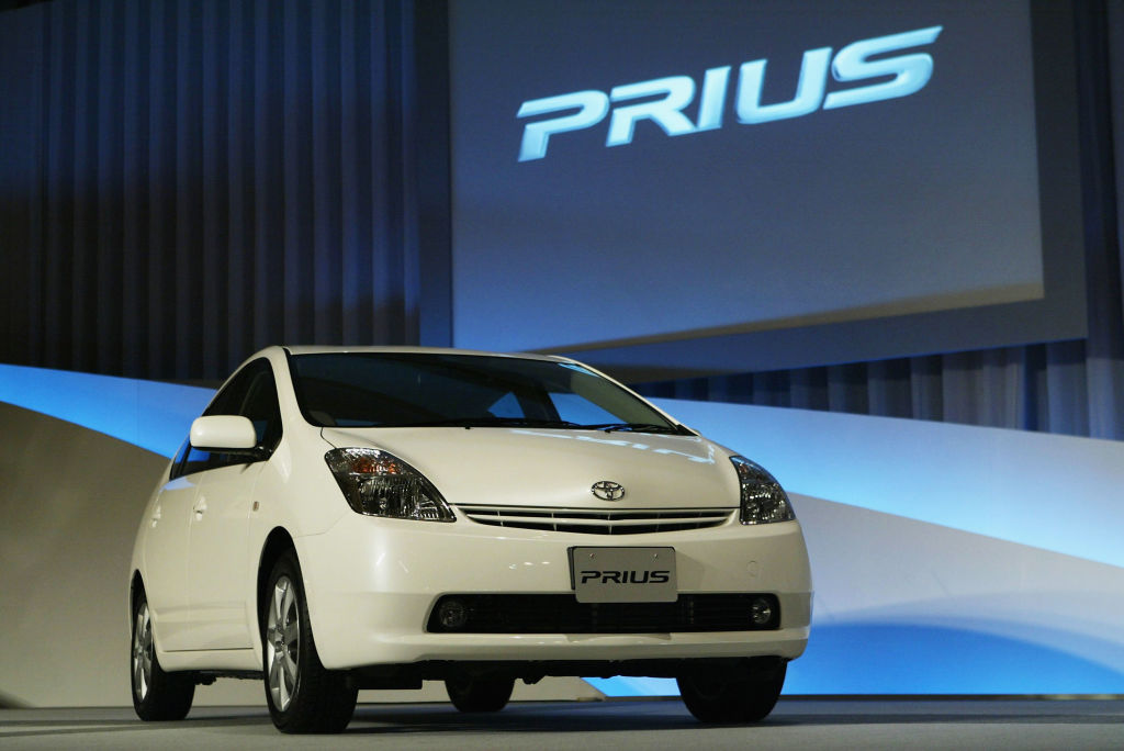 A white Toyota Prius on display at an auto show.