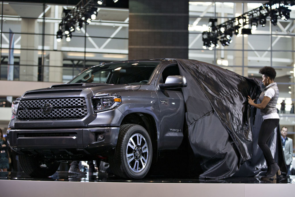 A Toyota Tundra pickup truck being unveiled at an auto show.