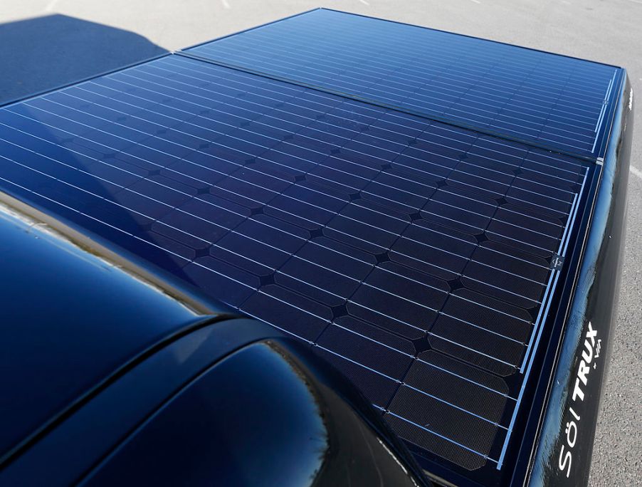 A solar truck bed cover installed on a black truck.