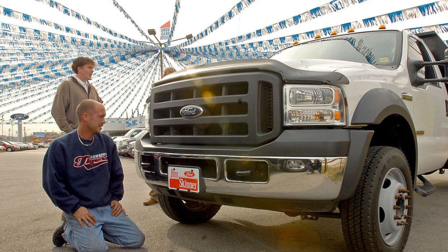 Sales associate shows a F-550 Ford truck to a potential buyer