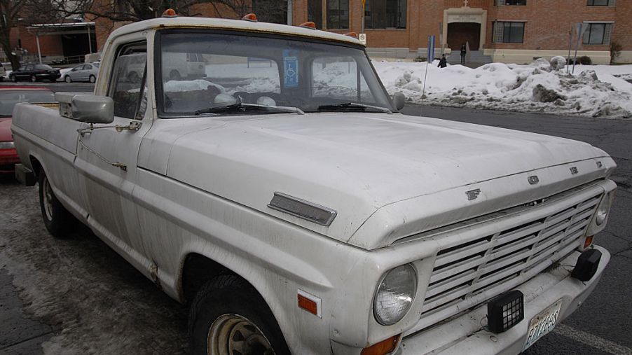 A used white Ford pickup truck parked on the road.