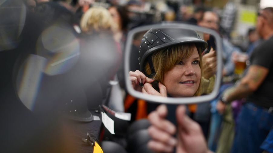 Woman tries on helmet at the Colorado Motorcycle Expo