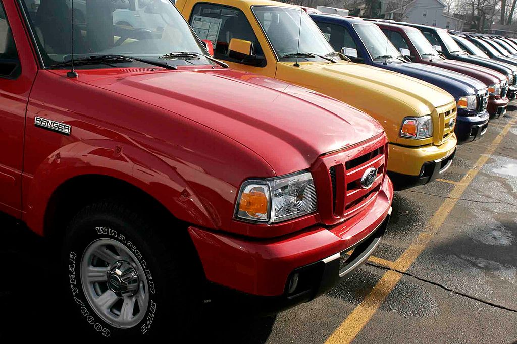 A line of used Ford pickup trucks at a dealership.