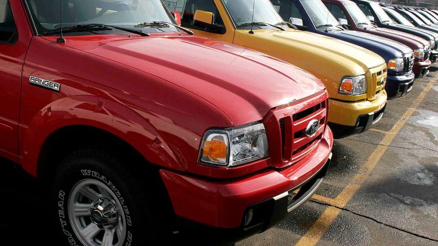A line of used Ford pickup trucks at a dealership.