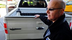 A man showing a used 2008 Ford F-150 pickup truck.