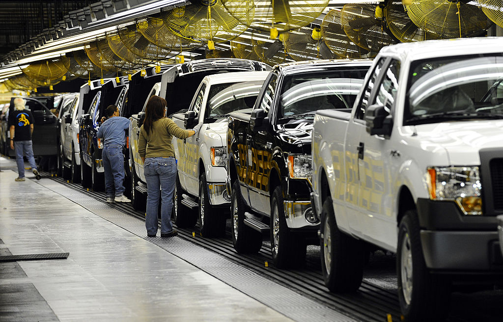 A pickup truck assembly line with different colored trucks being produced.