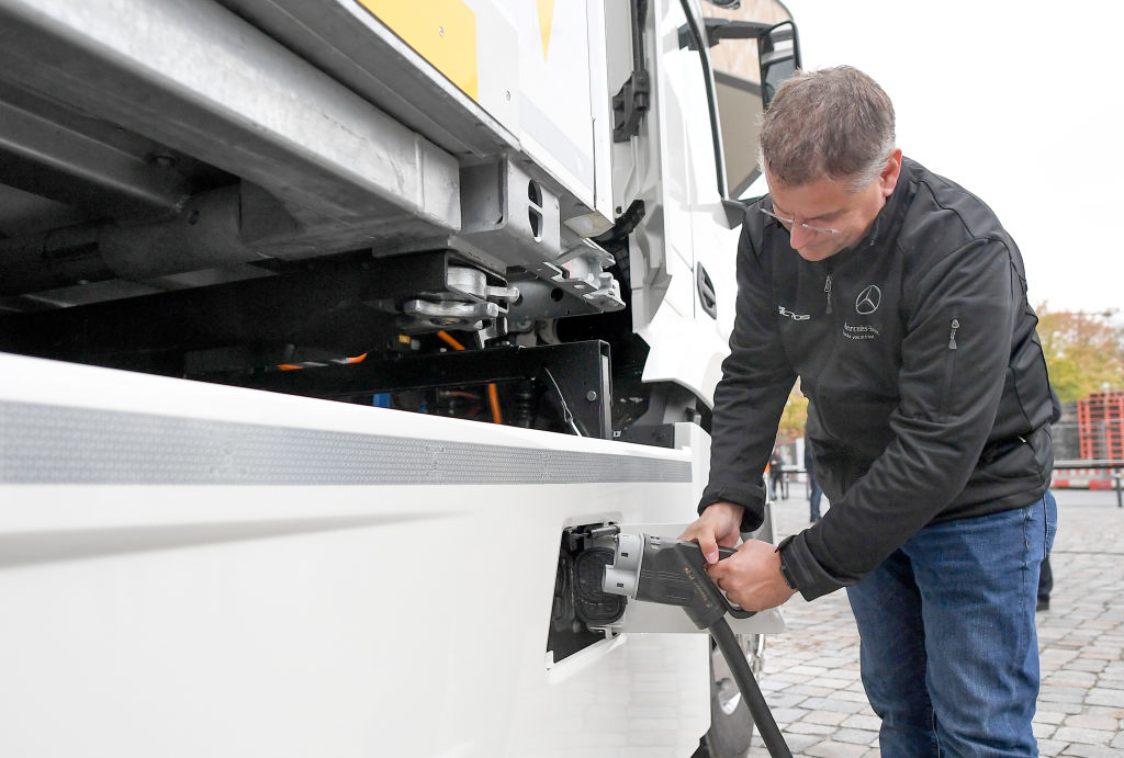 A man demonstrates how the batteries of the electric truck are charged. Hybrid and EV domination is on the horizon. 