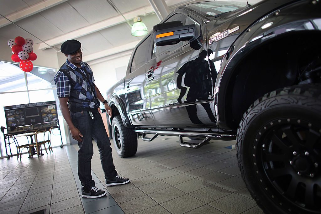A man looks at a F-150 pickup on the showroom floor at a Ford AutoNation car dealership