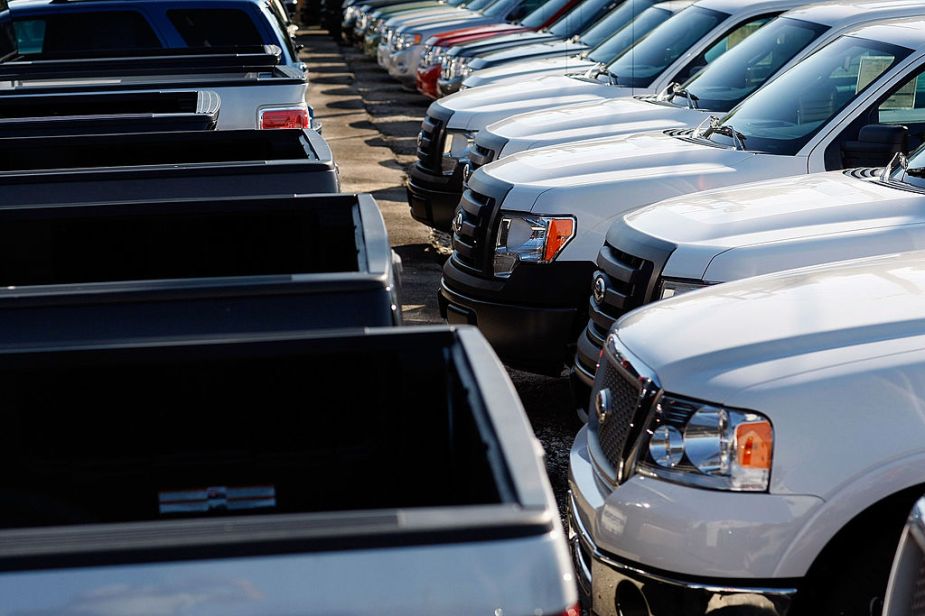 A row of Ford pickup trucks on sales lot.