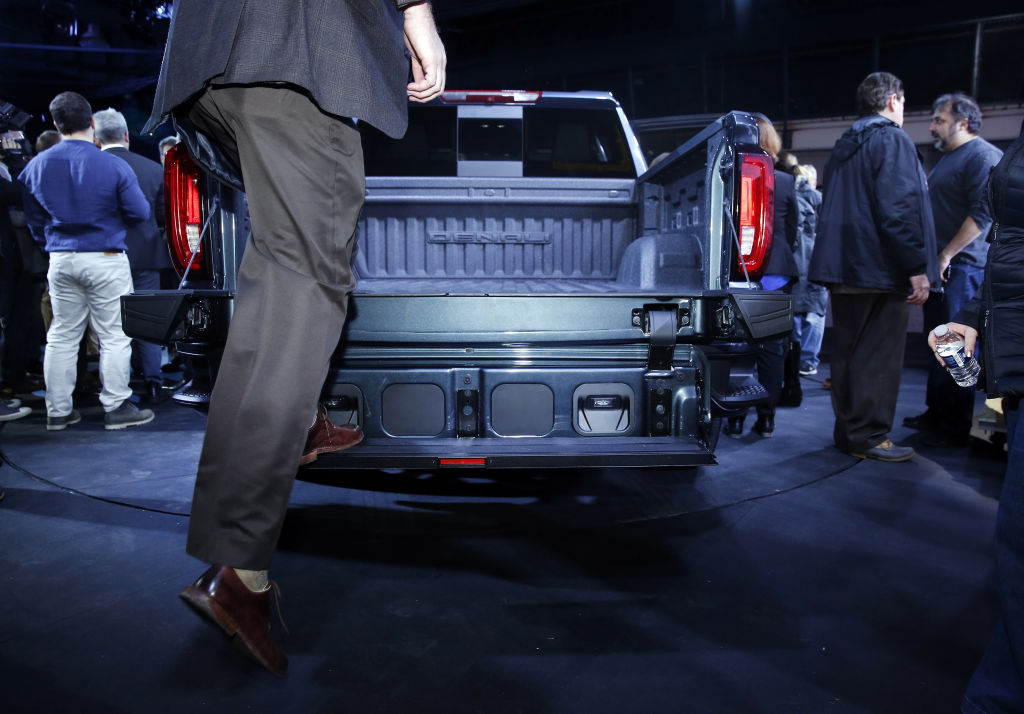 A man demonstrating how to use the new tailgate system in the GMC Siera