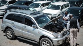 Customers check cars at a used car shop in Nairobi on October 4, 2017. AFP PHOTO / YASUYOSHI CHIBA (Photo credit should read YASUYOSHI CHIBA/AFP via Getty Images)