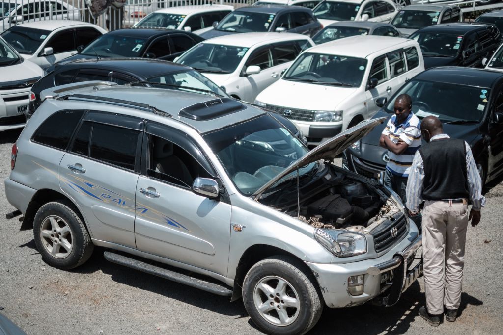 Customers check cars at a used car shop in Nairobi on October 4, 2017. AFP PHOTO / YASUYOSHI CHIBA (Photo credit should read YASUYOSHI CHIBA/AFP via Getty Images)