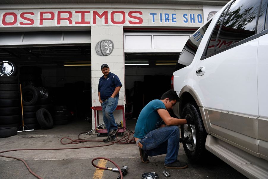 Mechanic Harry Gutierrez puts a tire back on a truck