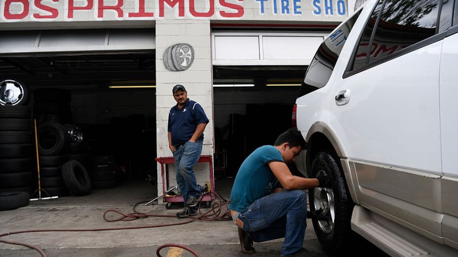 Mechanic Harry Gutierrez puts a tire back on a truck