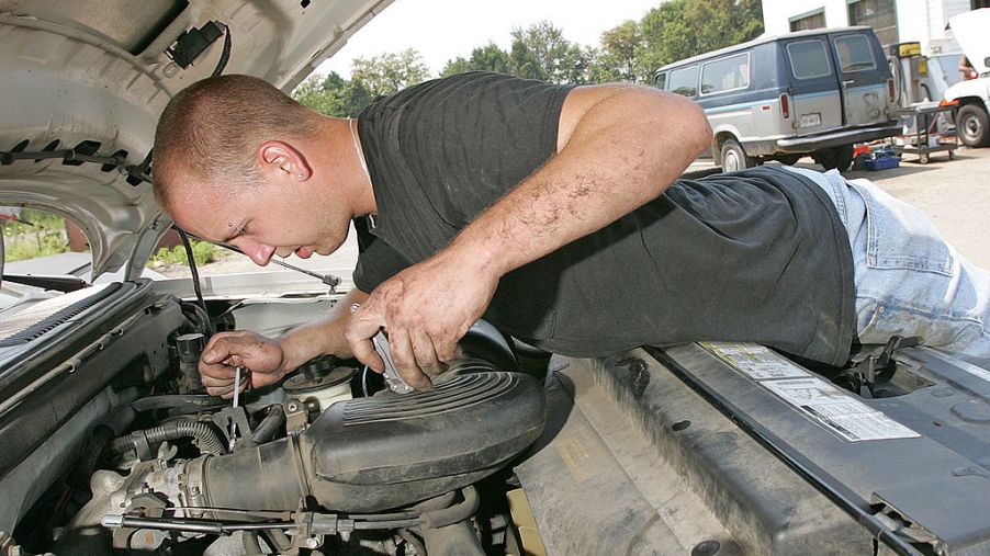 Service mechanic works on a truck engine