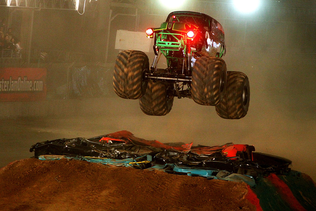 A monster truck launches off of a jump.