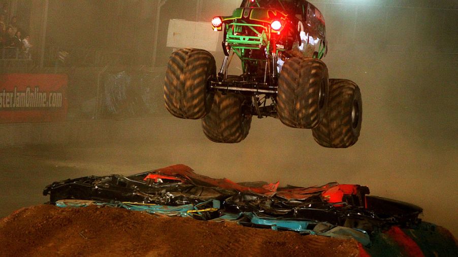 A monster truck launches off of a jump.
