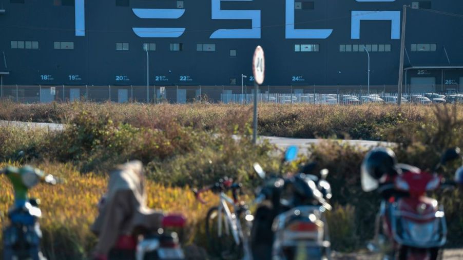 Motorcycles are parked next to the new Tesla factory built in Shanghai