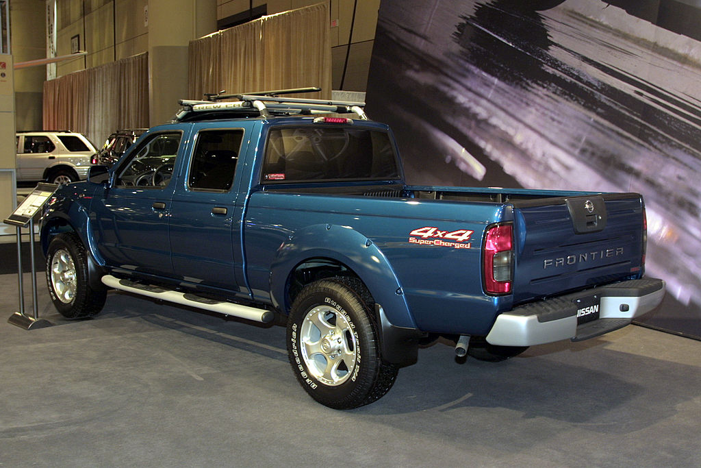 An older Nissan Frontier on display at an auto show.