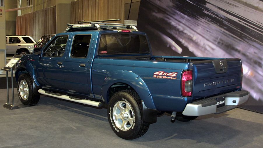 An older Nissan Frontier on display at an auto show.