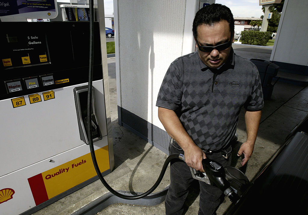 A man filing up his used pickup truck with gas.
