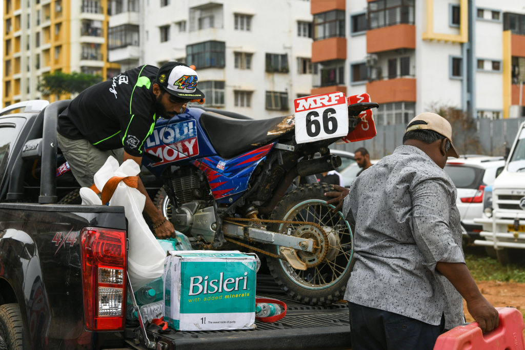 A guy unloads his dirt-bike from his truck.