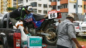 A guy unloads his dirt-bike from his truck.
