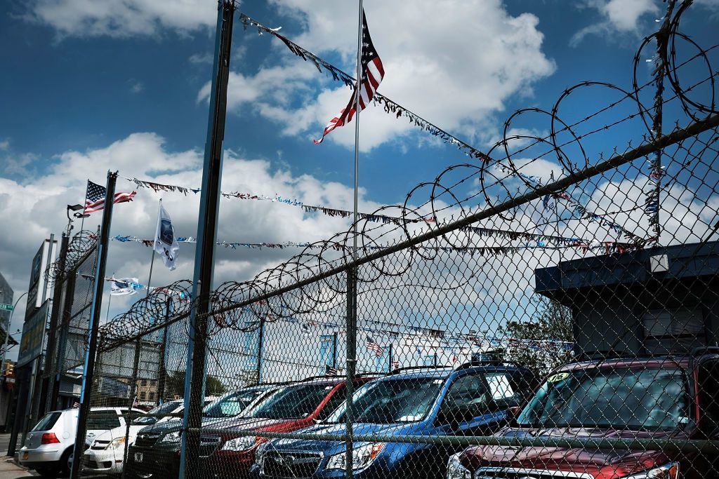 New cars sit in a lot at a Queens auto dealership