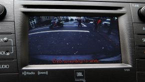 A dashboard showing a backup camera in the center of the screen.