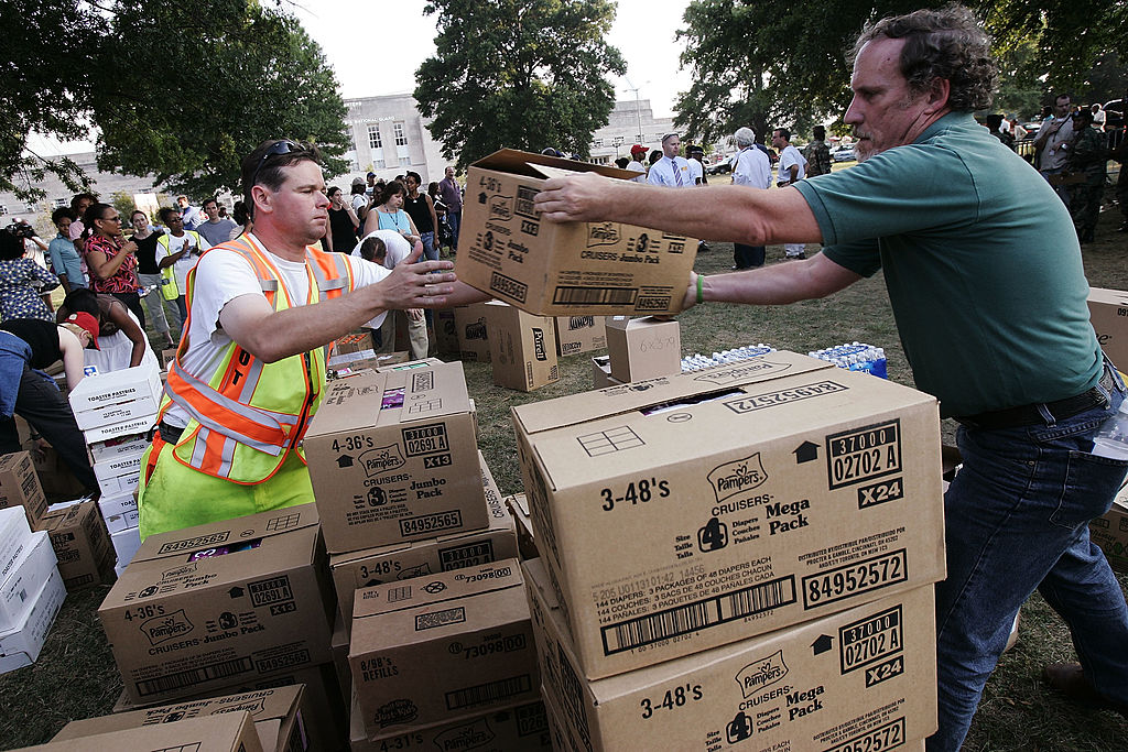 Workers help to distribute boxes full of supplies