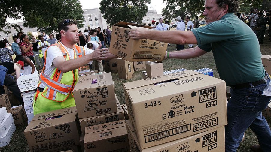 Workers help to distribute boxes full of supplies