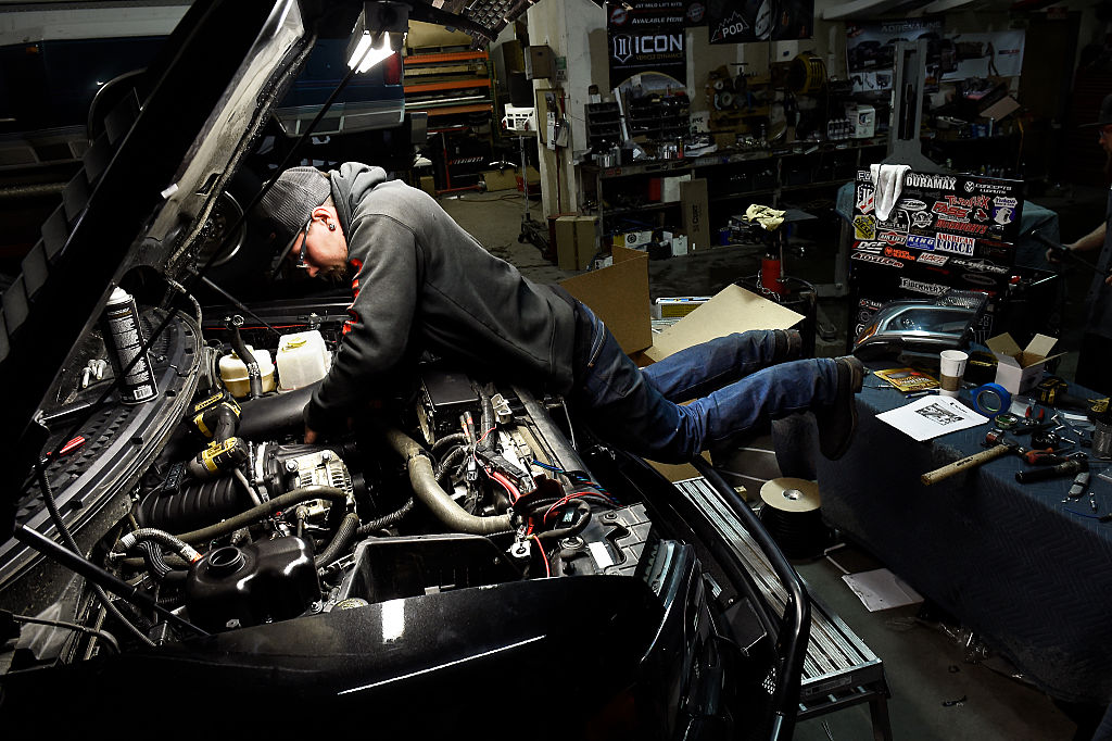 A mechanic working to fix a Ford F-150 with engine problems