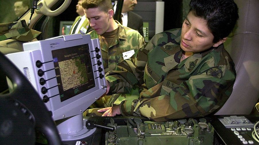 A soldier reading a GPS inside of a Ford military truck