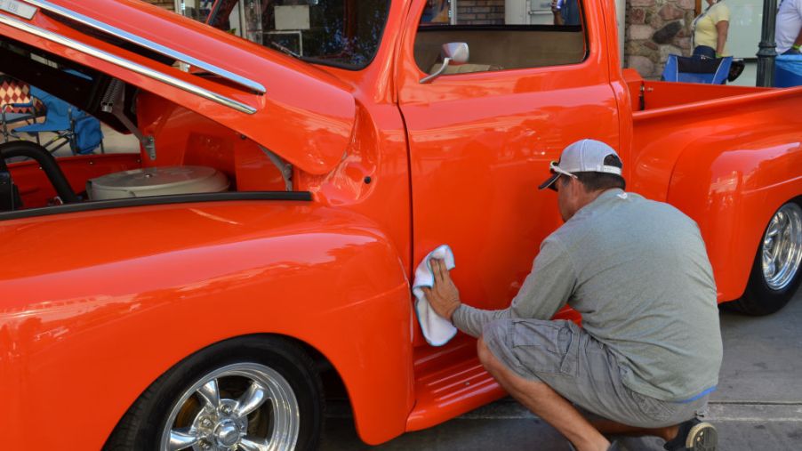 A Ford truck owner polishes the outside of his truck.