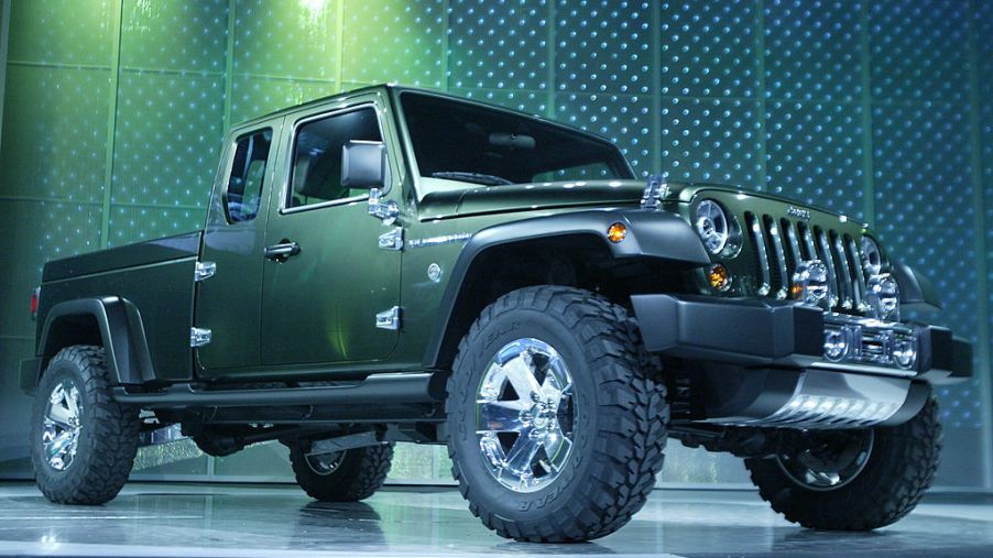A green Jeep Gladiator on display at an auto show
