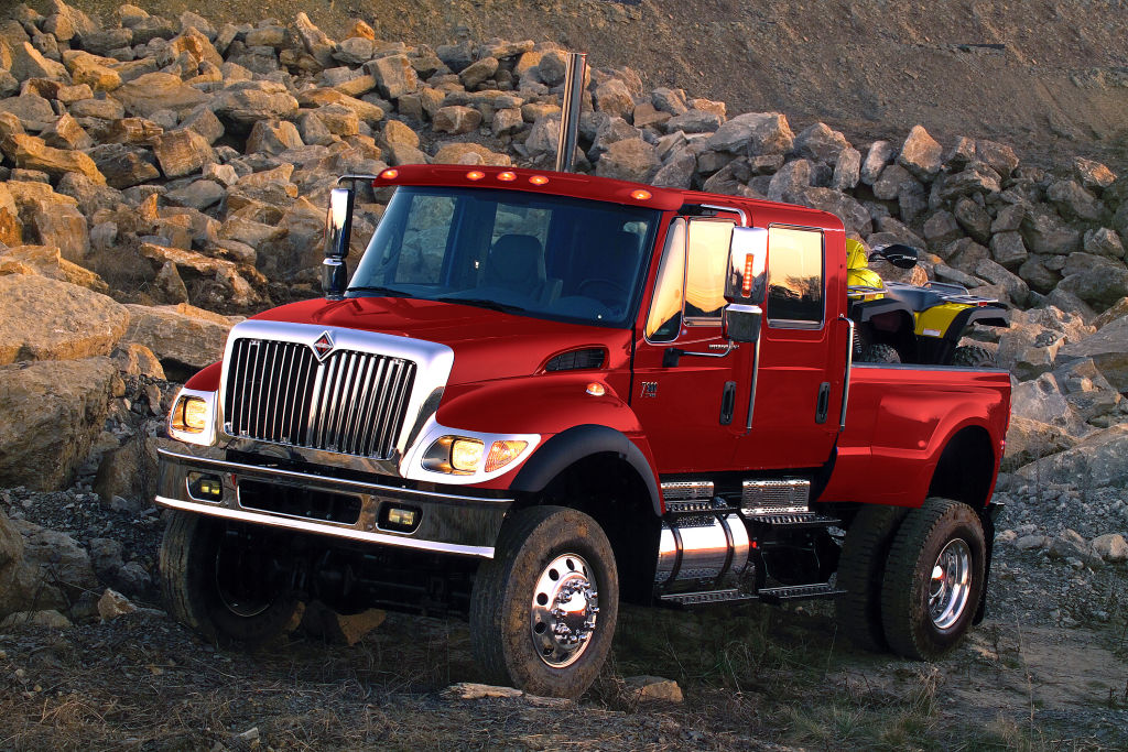 An International MXT truck driving over some rocks.