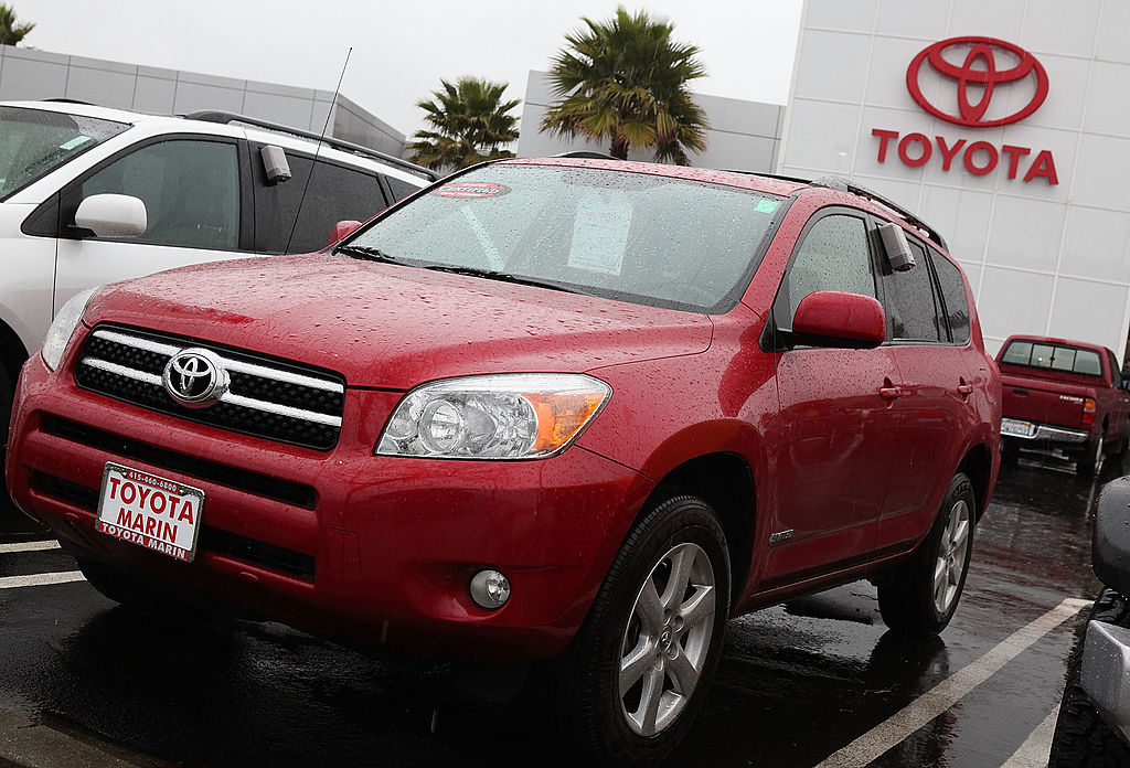 A red Toyota RAV4 on display at a car dealership.