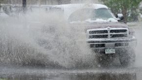 A truck splashes through a puddle off-road.