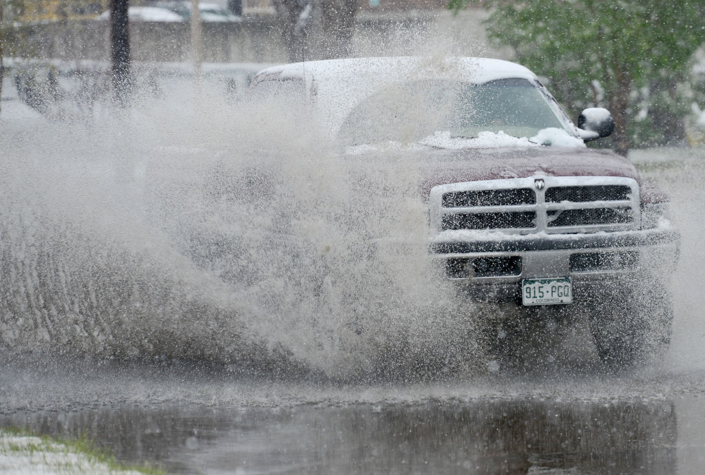 A truck splashes through a puddle off-road.