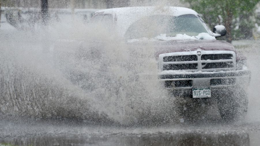 A truck splashes through a puddle off-road.