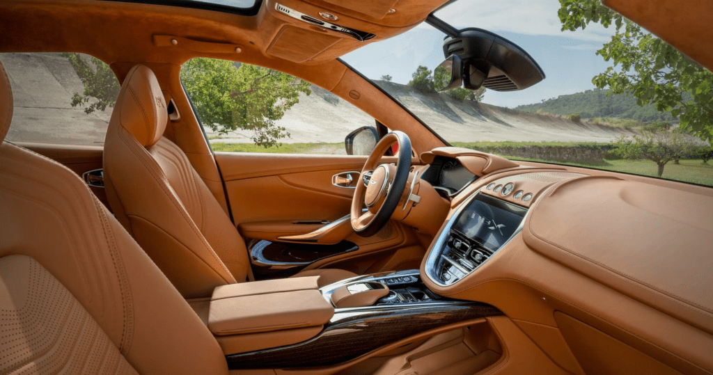 The light-brown-leather-and-wood-trim interior of the 2021 Aston Martin DBX