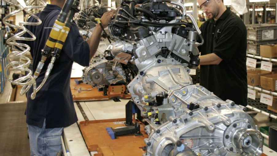 Assembly line workers do final inspection on a Jeep Wrangler engine
