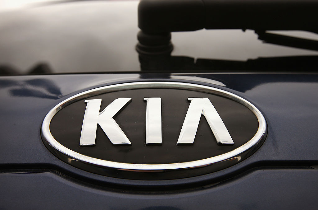 The logo on a Kia Sedona for sale at a Kia dealership.
